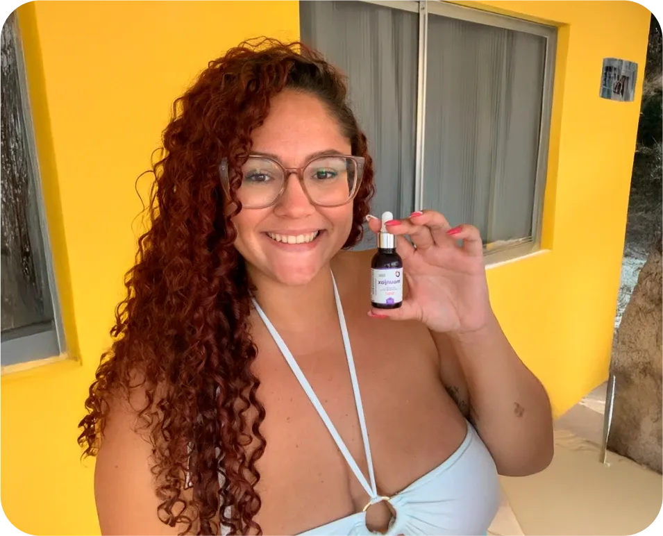 mulher com cabelos avermelhados sorrindo segurando embalagem do Mounjax